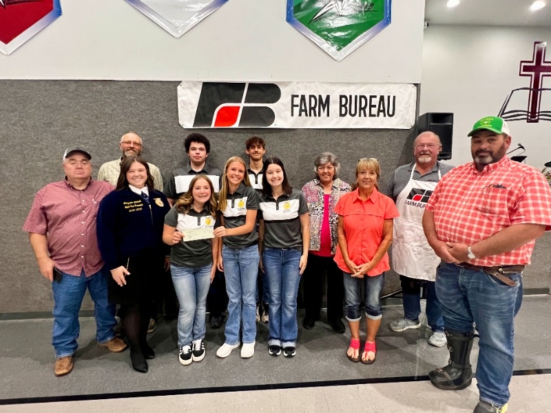 group of students standing in front of Farm Bureau sign